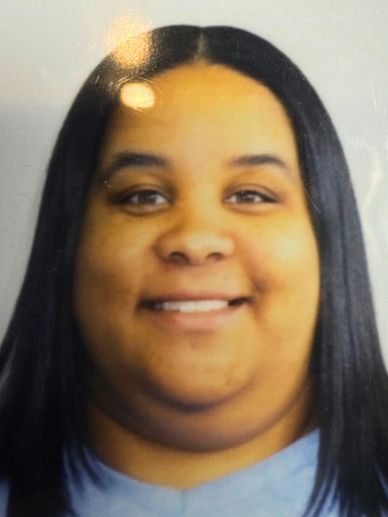 Smiling woman with long black hair and a blue shirt.