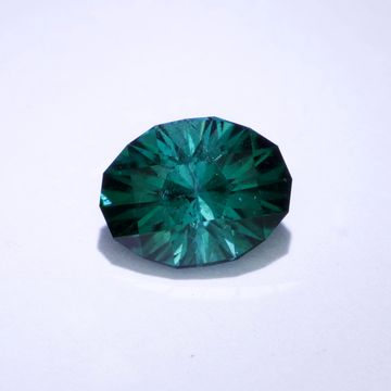 A single green faceted gemstone with a brilliant cut on a white background.