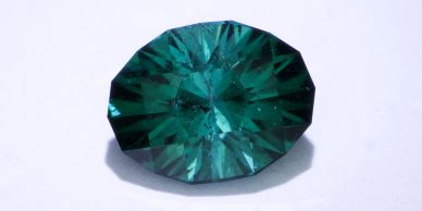 A faceted green gemstone with intricate cuts.