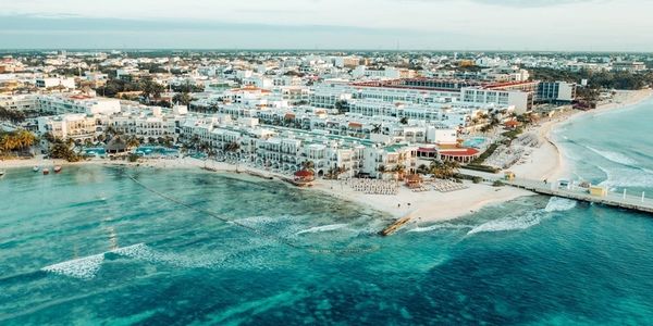Aerial view of a coastal city with clear turquoise waters and sandy beaches.