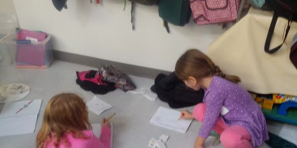 Two girl students working on floor