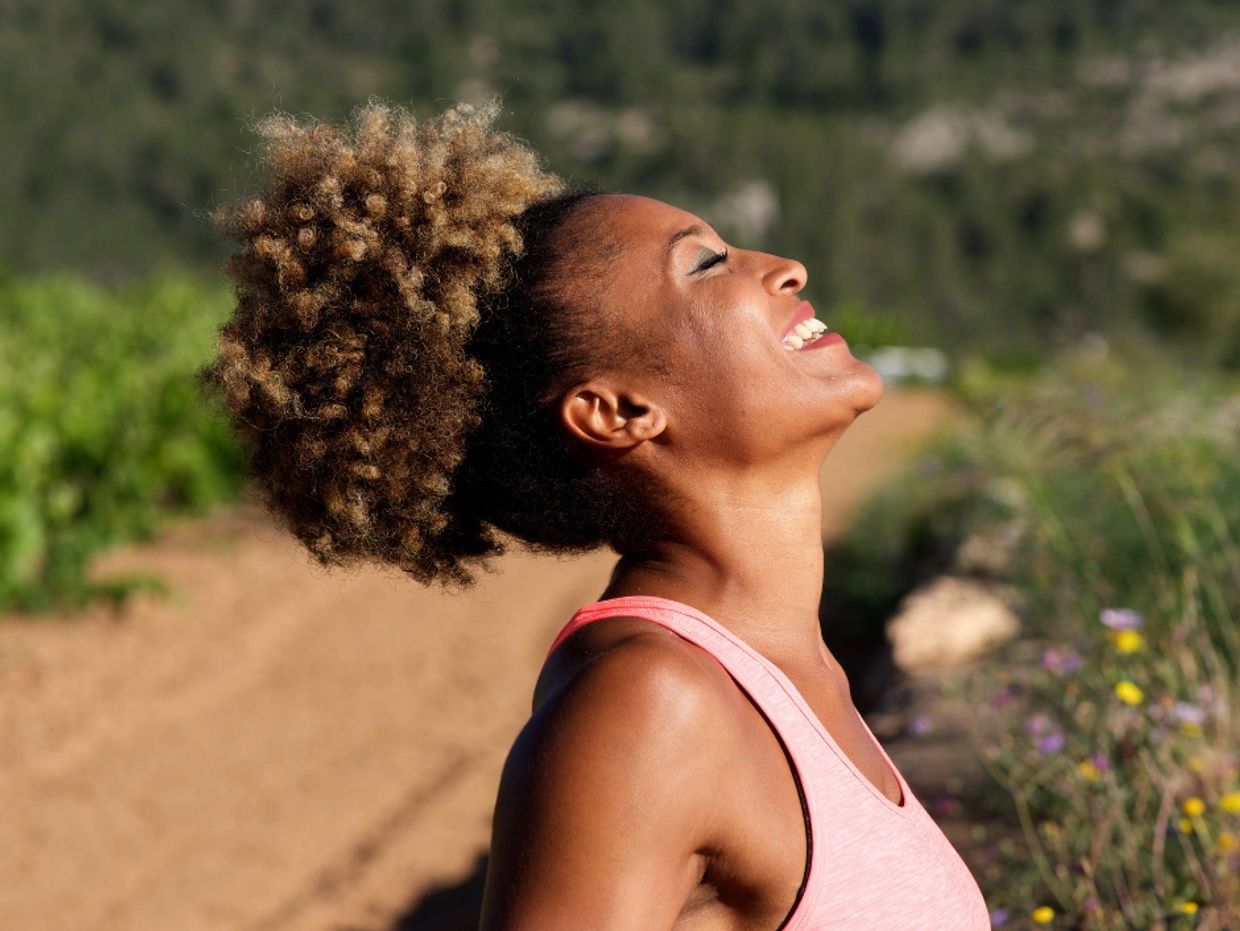Woman laughing joyfully outdoors.