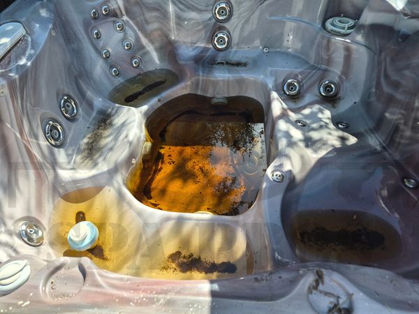 Sundance Spa with some brown dirty water in the bottom in need of a detail in North Hills