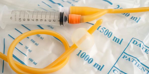 Sonde urinaire avec seringue sur sac de collecte.