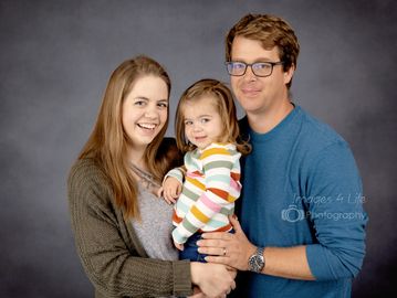 in studio family session with gray backdrop 