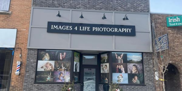 Photography studio storefront with images and sign.