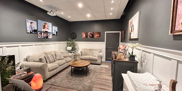 Cozy living room with gray sofas and family photos on walls.