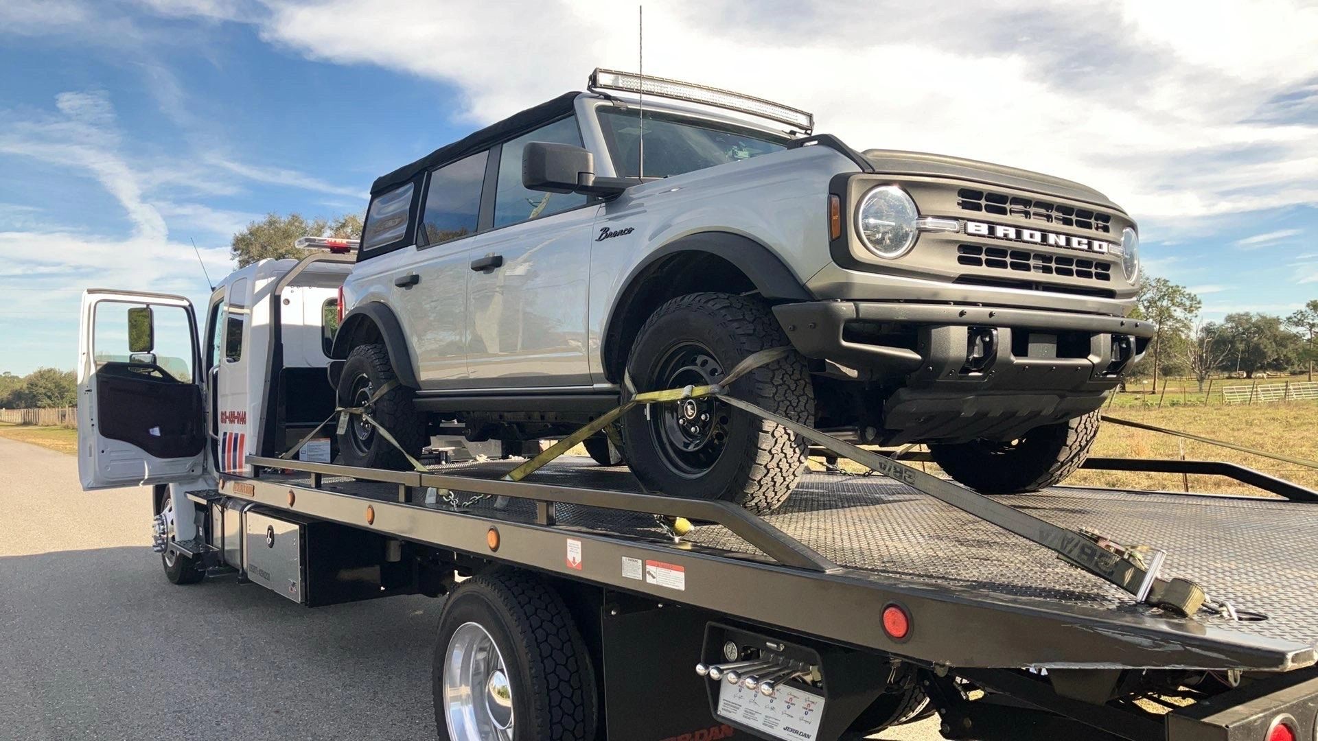 Flatbed tow truck loaded with a Ford Bronco in Lutz