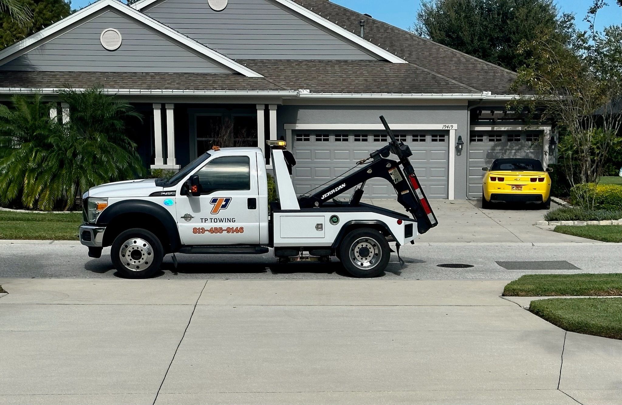 Side picture of a wheel lift tow truck in front of a customer's house in Zephyrhills