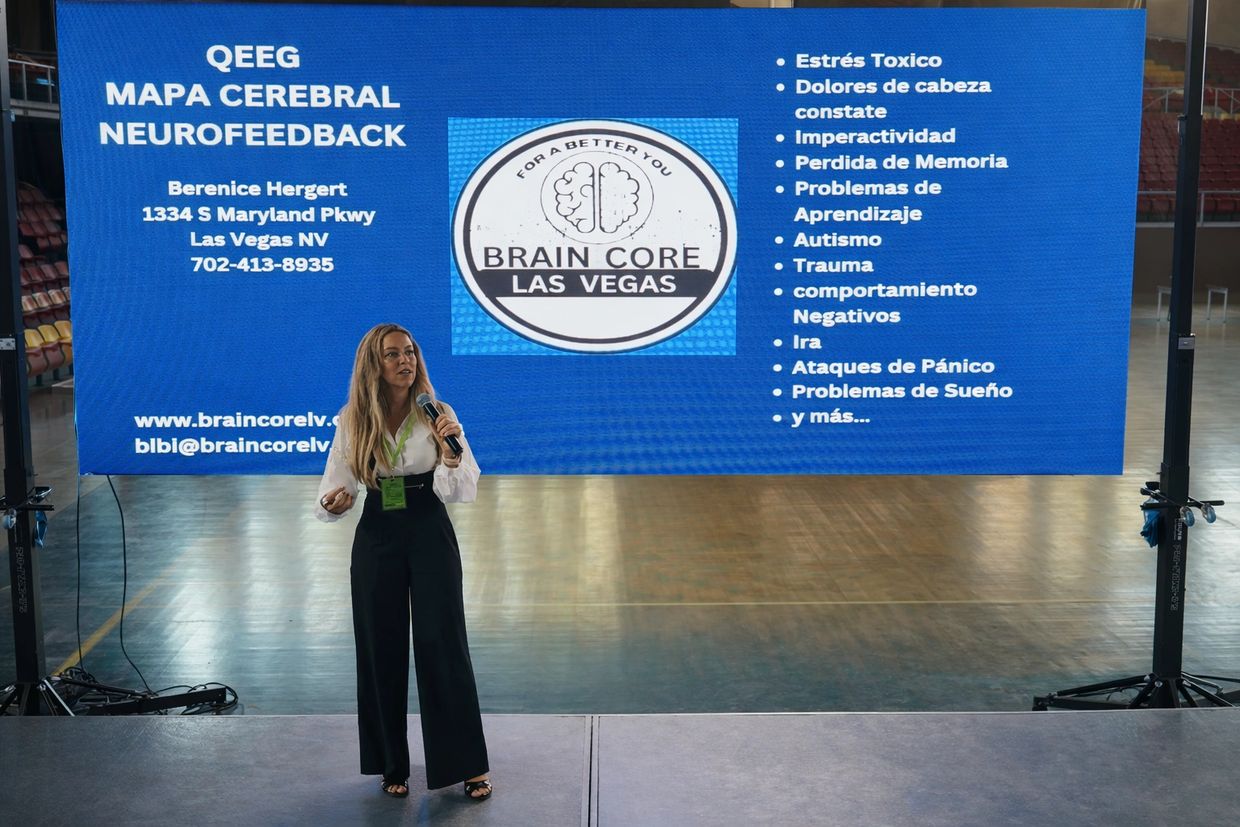 Woman presenting Brain Core Las Vegas neurofeedback services on stage.
