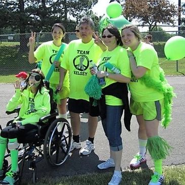 Group wearing bright neon green Team Kelsey shirts at an outdoor event.
