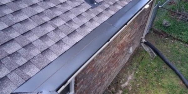 Newly installed seamless gutters on a brick house.