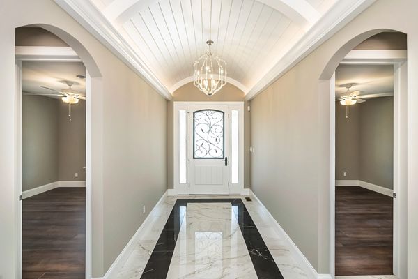 Stunning hallway with marble flooring, arched ceiling and doorways