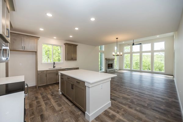 Kitchen with center island and cabinets by Waypoint. Kitchen is white with brown cabinets.