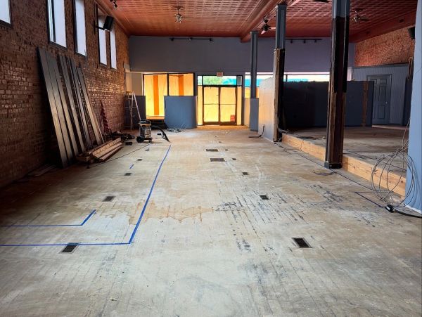 Empty indoor space under renovation with exposed brick walls.
