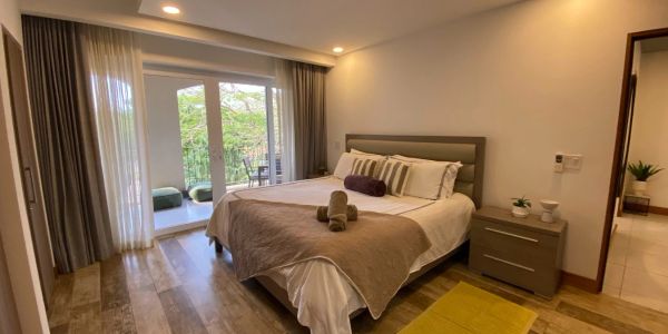 Cozy bedroom with a large bed and balcony access.
