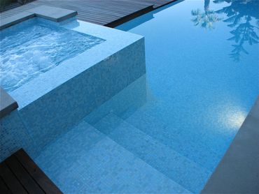 All tiled interior pool and spa with combination of wood and poured in place concrete coping.