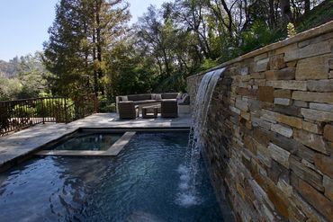 Stacked stone on raised bond beam with sheer descent next to your entertainment area = wow!