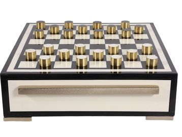 Chess set with gold and black pieces on a white board.