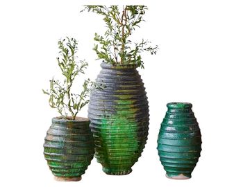Set of three green textured vases with plants in two.