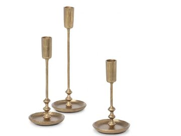 Three brass candlesticks of varying heights.