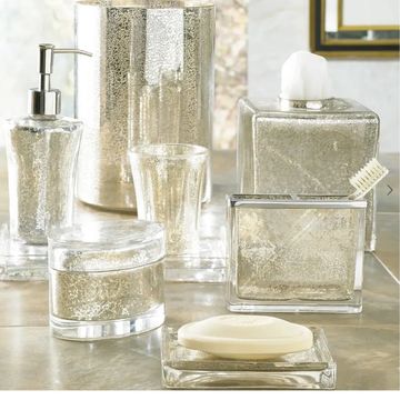Elegant silver bathroom accessories set on counter.