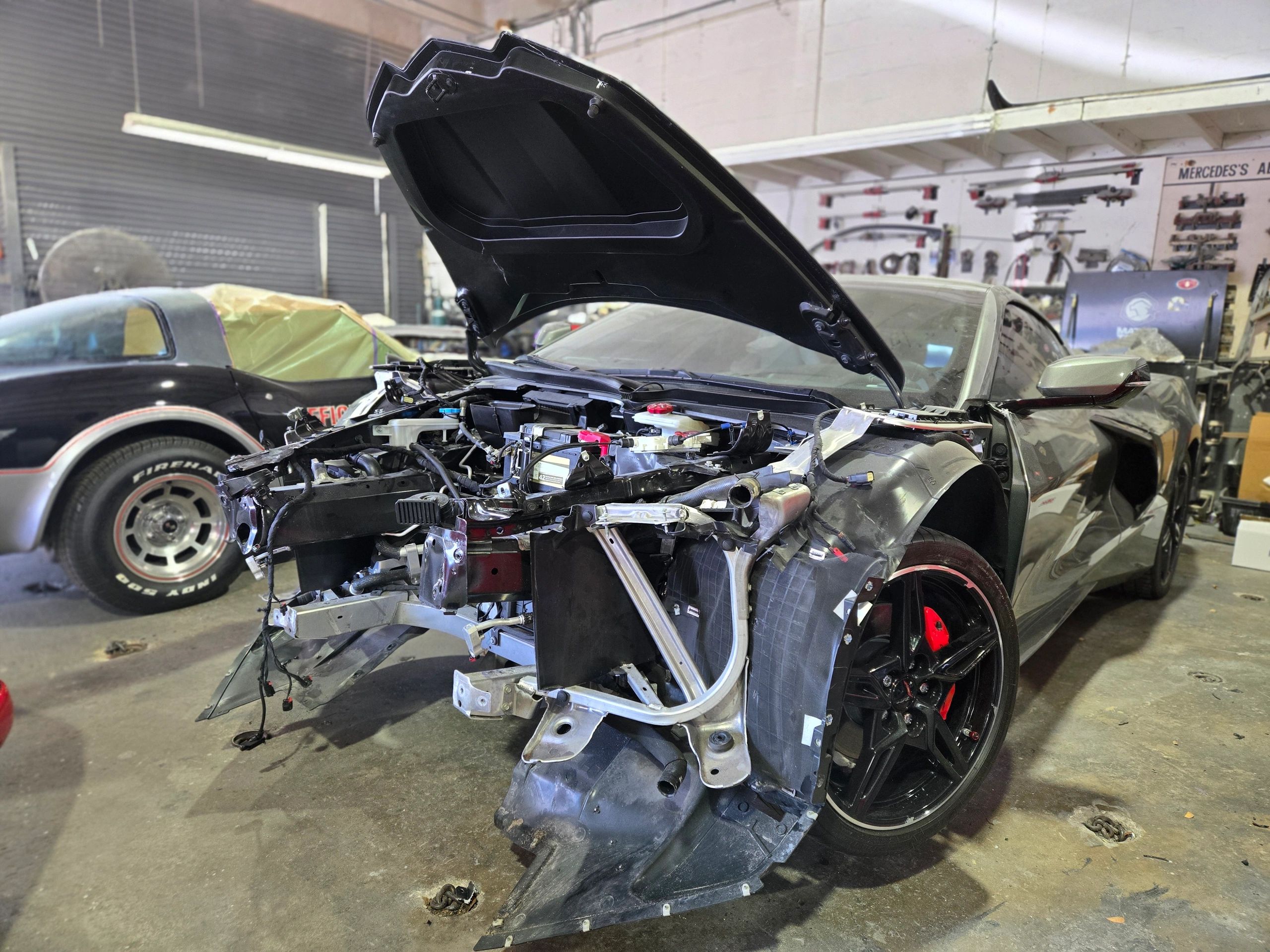 Car in a workshop with front end dismantled.