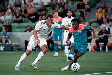 Two soccer players competing for the ball during a match.