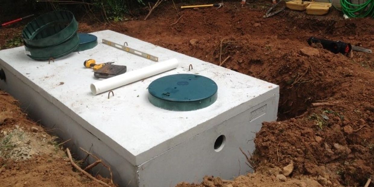 New septic tank being installed in the ground during residential septic system installation.