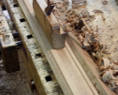 Using a hand plane to make an element of the cornice molding on a wardrobe.