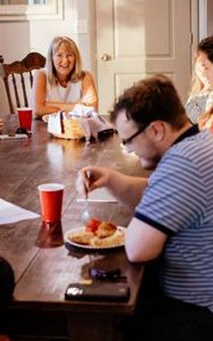 People sitting around a wooden table sharing a meal and socializing