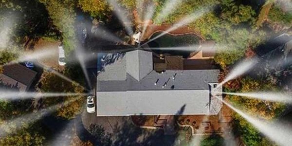 Top-down view of a house with multiple sprinklers watering the yard.