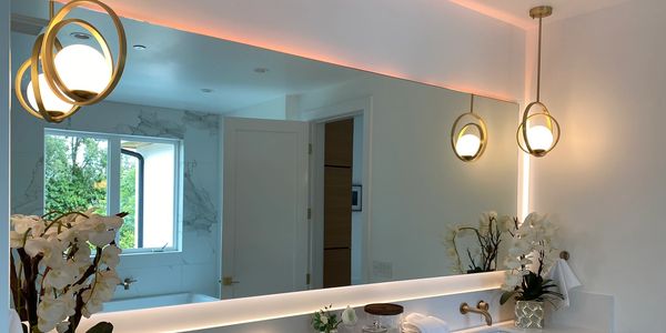 Modern bathroom with elegant lighting and large mirror.