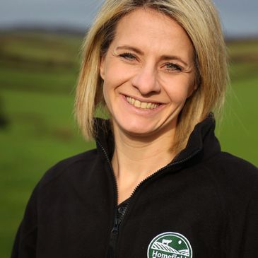 Smiling woman outdoors in a black fleece jacket.