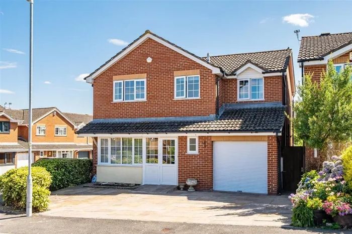 A brick two-story house with a garage and driveway.