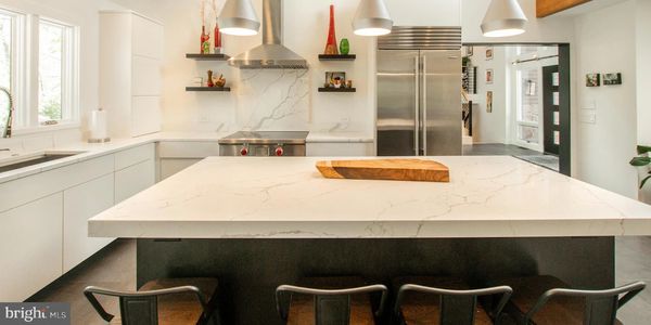 Modern kitchen with marble countertops and stainless steel appliances.
