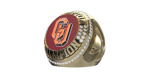 A gold championship ring with a red emblem and diamond accents.