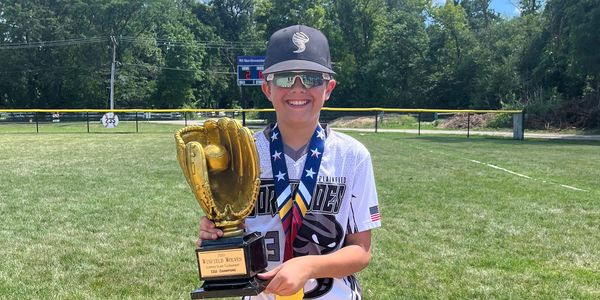 Baseball player holding a championship trophy. 