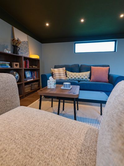 Cozy living room with blue sofa and wooden shelves.