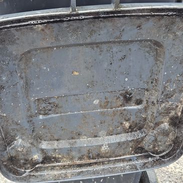 Dirty, worn-out plastic lid covered in grime and dirt.