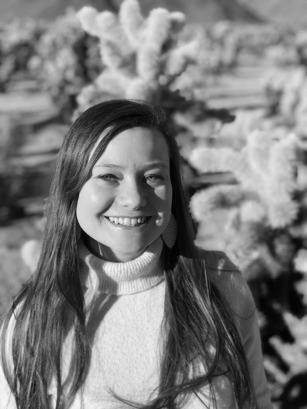 Smiling woman in turtleneck with nature background.