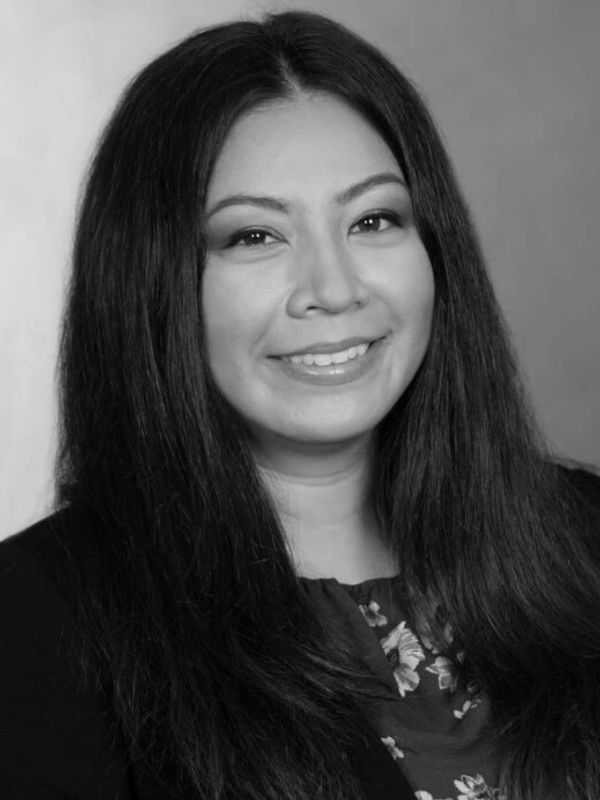 Black and white portrait of a smiling woman with long hair.