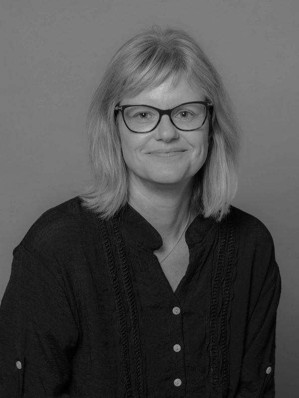 Portrait of a smiling woman with glasses.