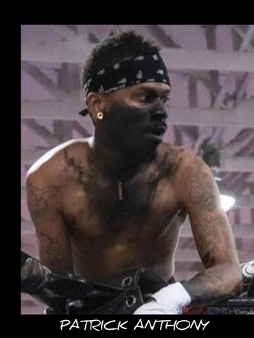 Shirtless man with face paint and bandana, intense look.