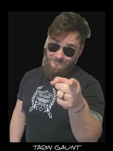 Man with beard and sunglasses pointing at the camera.