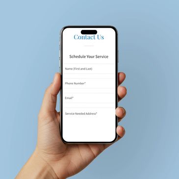 Hand holding a phone with a contact form on screen.