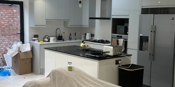 Modern kitchen with white cabinets, black countertops, and stainless steel appliances.