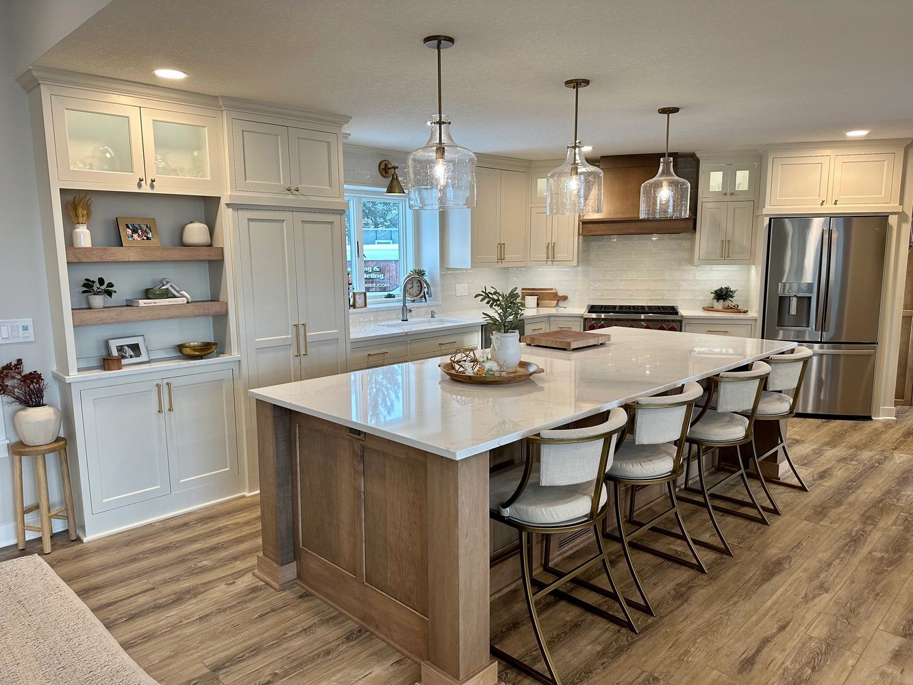 Modern kitchen with a large marble island and stylish pendant lights.
