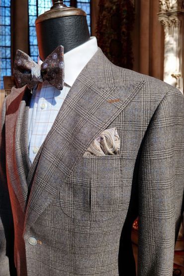Brown glen plaid suit with soft peak lapels, hand-finished pickstitching, and patch pockets.