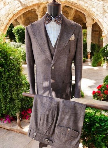 Classic brown glen plaid three-piece suit with peak lapels and side tab trousers. Timeless elegance.